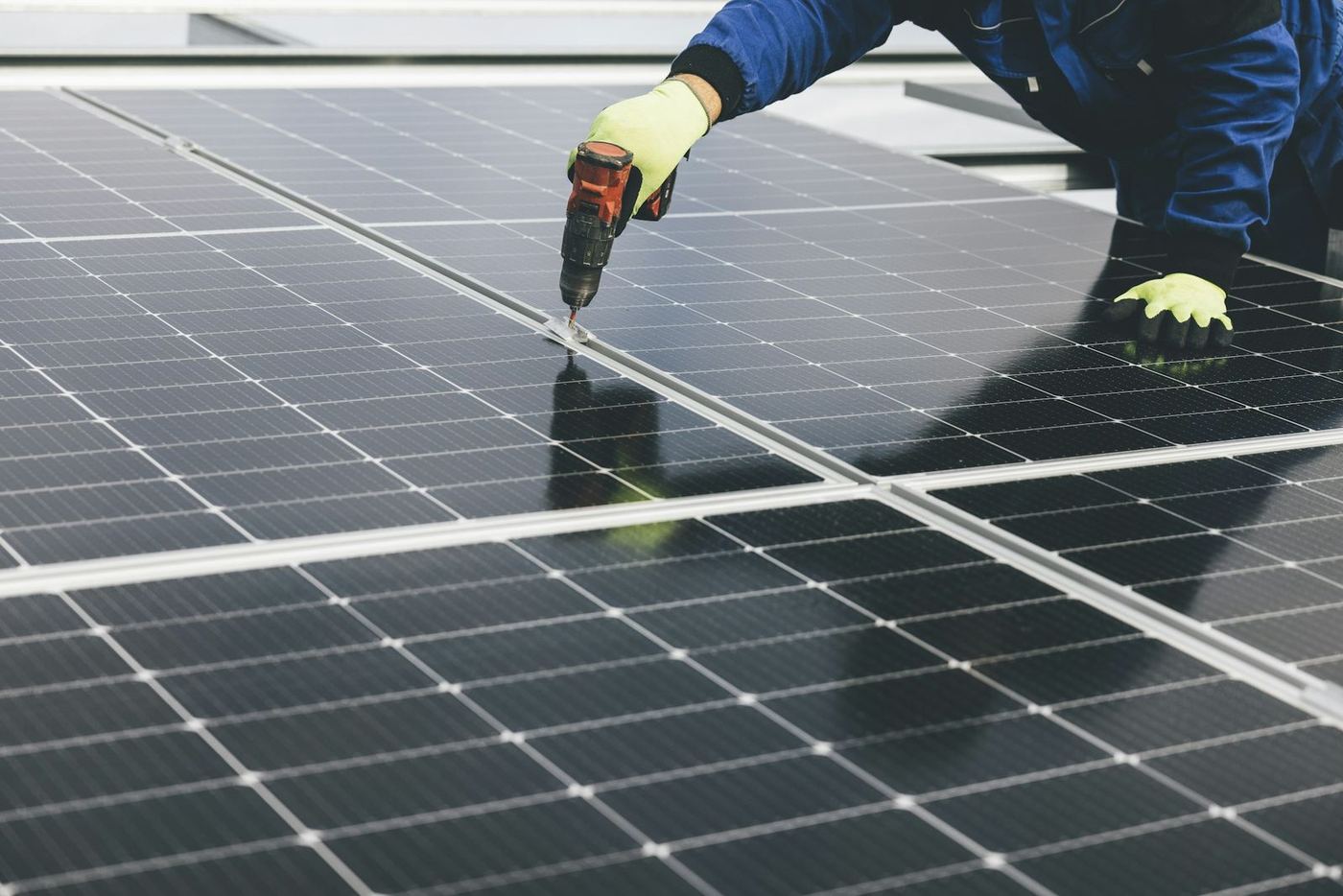 Technician fitting a solar panel on a roof